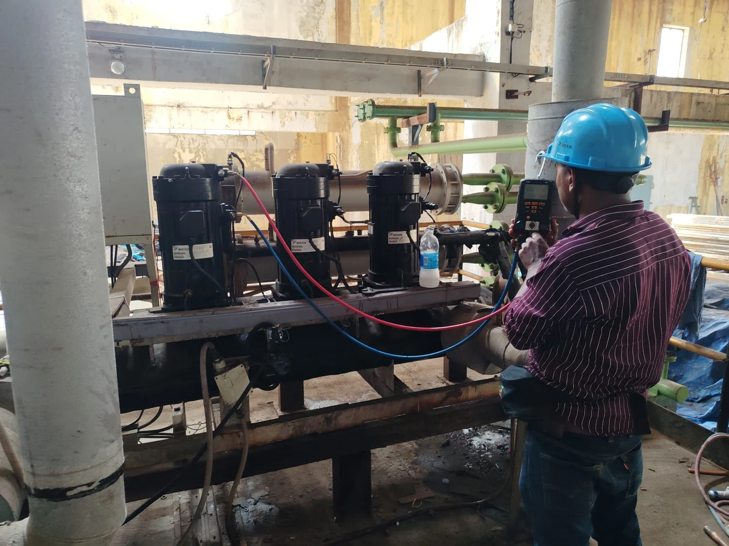 Technician servicing refrigeration compressors